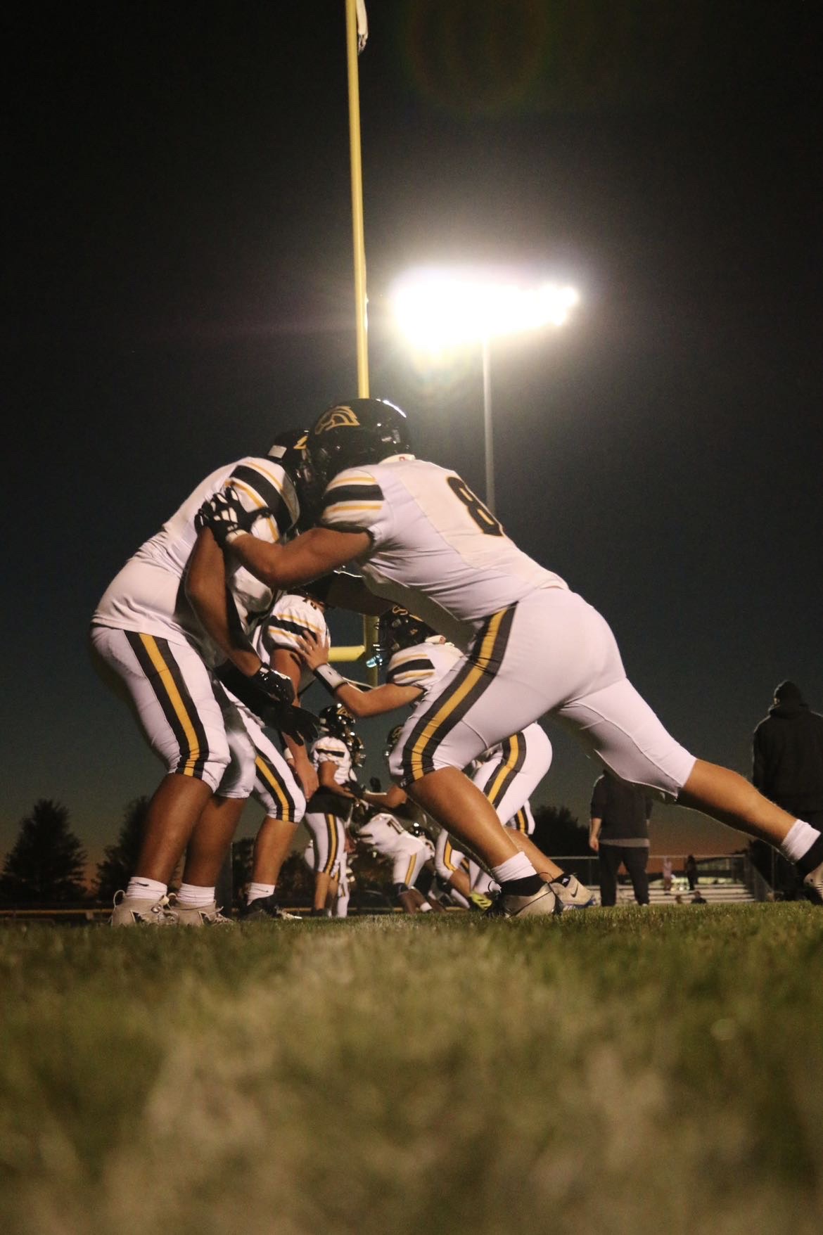 Football player in action pose during outdoor game - Sports photography by Timmy Miller