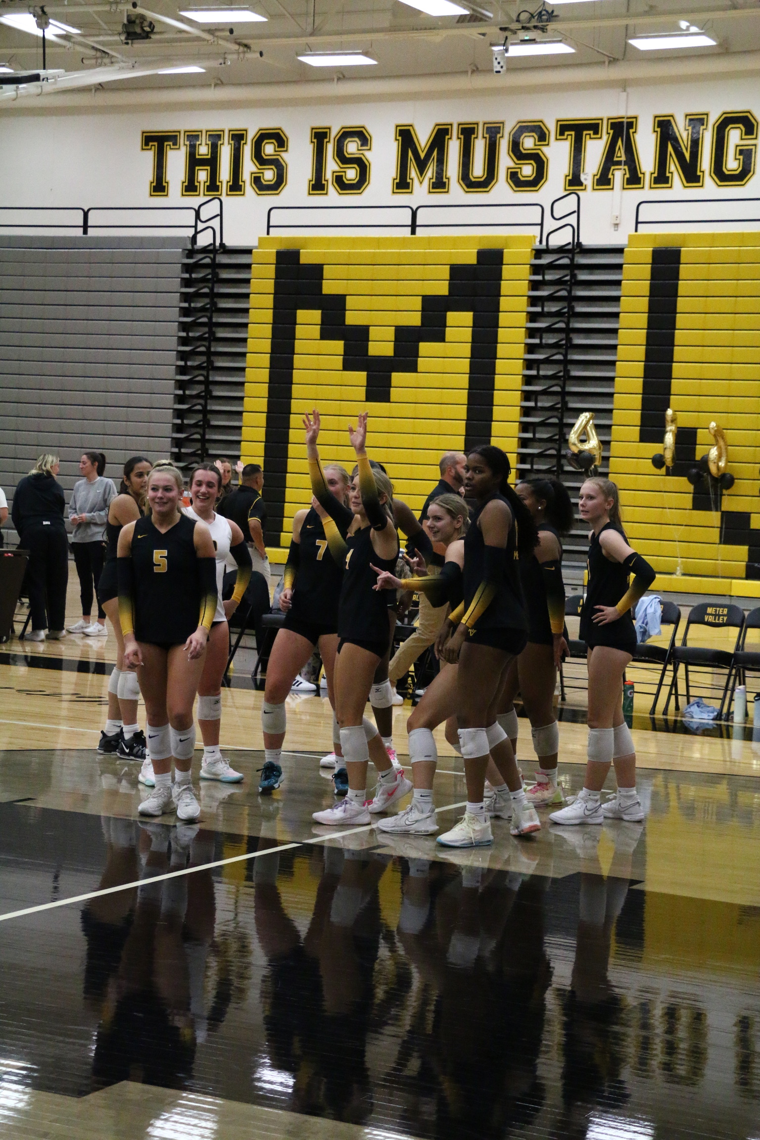 Volleyball team celebrating point during indoor match - Athletic photography by Timmy Miller