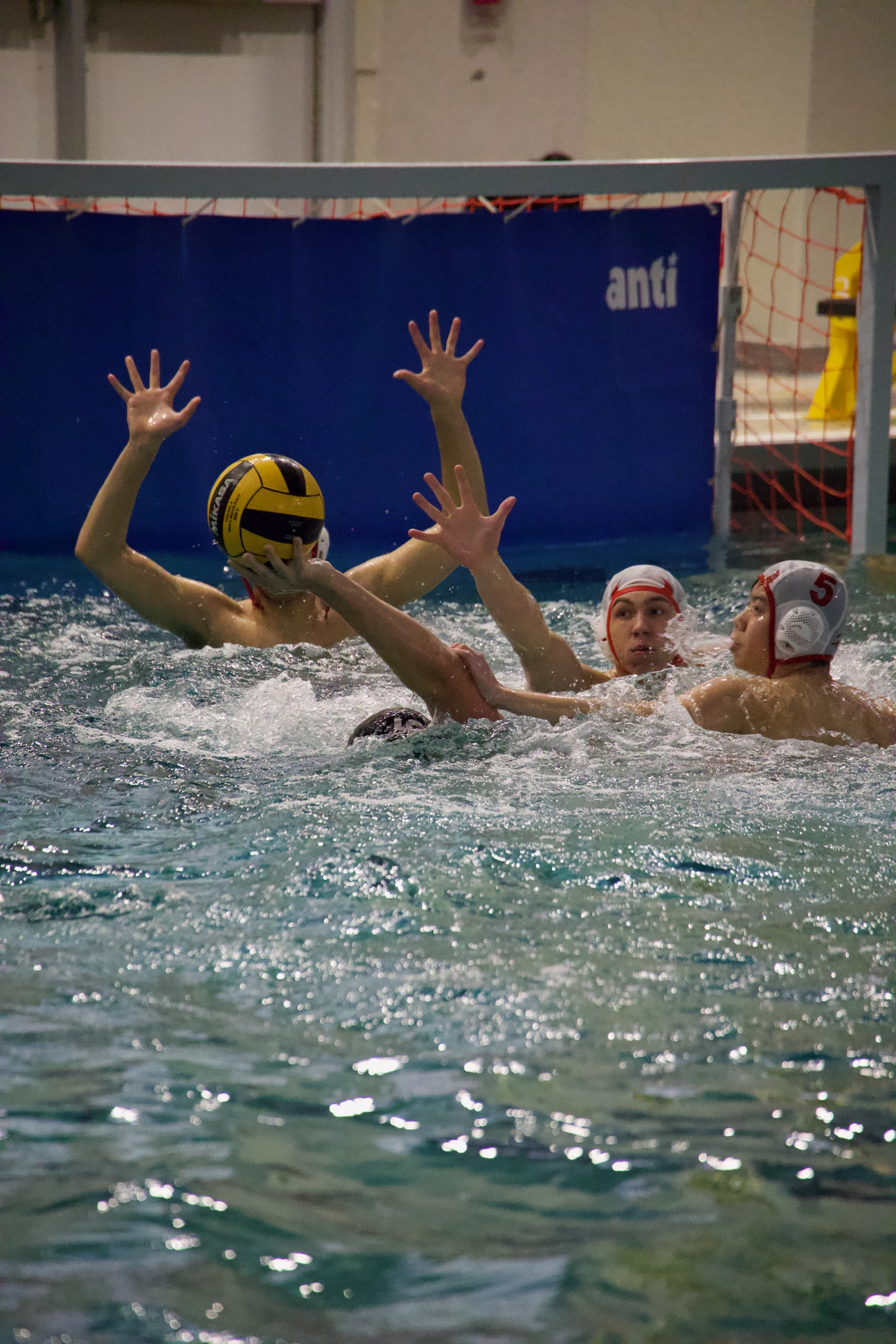 Water polo goalkeeper blocking shot during high school championship - TMM Sports Photography